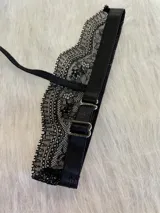 Conjunto de lencería de tres piezas en encaje negro. Incluye bralette con breteles regulables y collarín integrado, y tanga regulable con corte media less.