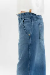 Pantalón de jean de tiro medio y pierna ancha, confeccionado en denim 100% algodón. Diseño con 5 bolsillos y pespuntes a contratono.