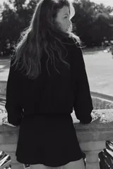 Campera bomber negra con cuello elevado, cierre frontal bidireccional y bolsillos laterales discretos. Cuenta con puños y dobladillo elásticos.