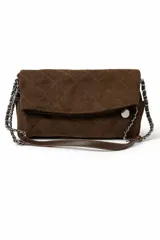 Cartera tipo sobre de gamuza marrón con diseño acolchado de rombos y costuras en contraste. Cuenta con una correa de cadena metálica entrelazada con una tira de cuero sintético y un detalle de dije circular metálico en el frente.