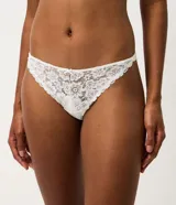Kit de dos bombachas bikini Lov confeccionadas en encaje floral con leve transparencia, una en color negro y otra en color blanco. Cuentan con un diseño cómodo y un pequeño lazo decorativo con dije metálico en la parte delantera.