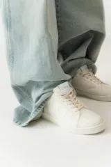 Championes de cuero color blanco con detalle de corona en animal print y talón verde. Cuentan con suela de caucho, lengüeta de gamuza y forro textil, con cierre mediante cordones al tono.