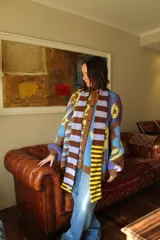 Bufanda tejida a rayas horizontales en tonos marrón, beige y rojo.