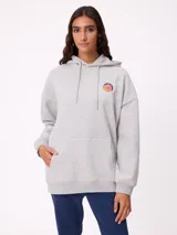 Canguro gris con capucha, de corte oversize, con estampado gráfico multicolor en la espalda que incluye diversos parches y logotipos de la marca Rusty.