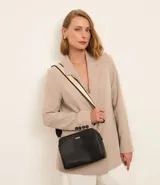 Bolso bandolera de tamaño mediano confeccionado en poliuretano, con diseño rectangular y cierre de cremallera. Cuenta con una correa ajustable de cinta gross con detalles en contraste.