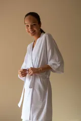Bata estilo kimono de algodón en color gris azulado, con mangas al codo y largo por encima de la rodilla. Incluye lazo de ajuste en la cintura.
