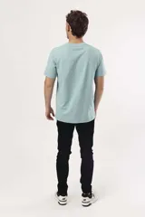 Remera blanca de algodón con cuello redondo y manga corta. Estampado frontal con una ola azul, un sol naranja y el texto "SURF UNTIL SUNSET".