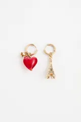 Par de aros tipo argolla dorados con diseño asimétrico. Uno de los aros presenta un dije de corazón rojo de vidrio y el otro un dije metálico con forma de la Torre Eiffel.