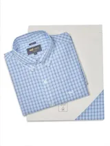 Camisa de manga larga RKF con estampado de cuadros en tonos azules y blancos. Presenta cuello abotonado, cierre frontal con botones y un bolsillo en el pecho con el logo de la marca bordado.