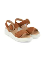 Sandalias de gamuza color tostado, con plataforma blanca estriada y tira ancha en el empeine. Cuenta con tira ajustable al tobillo con hebilla redonda grande de carey.
