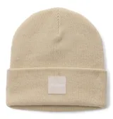 Gorro tipo beanie de tejido grueso color beige, con diseño de punto acanalado y vuelta en el borde. Presenta un parche cuadrado frontal con el logo de la marca Columbia.