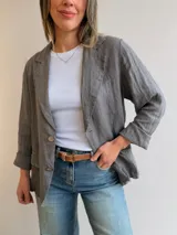 Blazer de lino color gris oscuro, con cuello de solapa, cierre frontal de dos botones y bolsillos con solapa en la parte delantera.