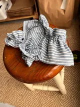 Cuellito y puños de camisa a rayas celestes y blancas con volados.