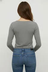 Remera blanca de manga larga, de algodón y elastano, corte ajustado y cuello redondo.