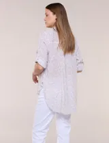 Camisa holgada de algodón liviano con estampa botánica en tonos beige y blanco, cuello camisero y mangas largas.