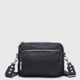 Cartera tipo bandolera de Bubba, color negro, con diseño acolchado y múltiples compartimentos con cierre metálico. Incluye correa ajustable con detalles de remaches metálicos.
