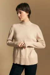 Polera de cuello alto confeccionada en tejido de punto negro, con diseño de textura acanalada en cuello, puños y ruedo, y trama vertical en mangas y espalda.