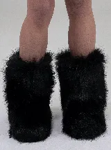 Botas de caña media confeccionadas en piel sintética de pelo largo color negro, con suela de goma.