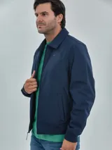 Campera azul marino de poliéster, manga larga con cierre de cremallera, dos bolsillos inferiores y logo de Tommy Hilfiger bordado en el pecho.
