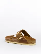 Sandalias Birkenstock modelo Gizeh Big Buckle color marrón cuero, con plantilla anatómica de corcho y látex cubierta de cuero. Presentan una tira delantera con hebilla grande dorada ajustable. Suela de EVA.