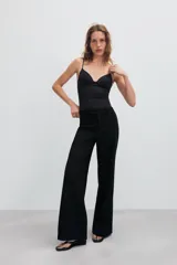 Pantalón de tiro medio color tostado, con pernera recta, trabillas para cinturón y cierre frontal con cremallera y botón oculto.