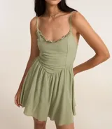 Enterito corto de viscosa color verde oliva, con breteles finos, escote con detalle de volados y corte entallado en la cintura con falda acampanada.