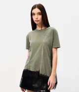 Remera verde militar de algodón con efecto desteñido, cuello redondo, mangas cortas, recortes asimétricos y detalle de encaje negro en el bajo irregular.