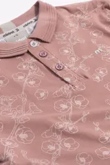 Remera cuello polo de algodón con estampado floral, manga corta con terminaciones a contratono y cierre frontal con botones.