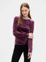 Remera de manga larga confeccionada en terciopelo color violeta, con cuello bote y mangas acampanadas.