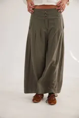 Pantalón de tiro alto color verde militar, de corte amplio y pierna ancha, con cierre frontal de botones y pinzas en la cintura.