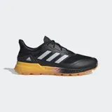 Championes deportivos Adidas Adipower Field Hockey 2.1, color negro con tres franjas plateadas en el lateral. Posee una entresuela gruesa de color amarillo mostaza y suela de goma color caramelo con tacos multidireccionales.