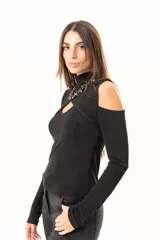 Polera negra de manga larga con diseño de hombros descubiertos y cuello alto. Presenta un recorte frontal en el pecho que crea un efecto de superposición.