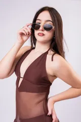 Vestido largo de tul color marrón con diseño de top halter y falda con volados laterales. Presenta una estructura de malla semitransparente que aporta movimiento y elegancia.