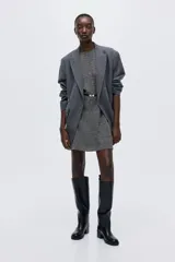 Vestido corto entallado color gris oscuro con cuello redondo, mangas raglán cortas y cierre oculto en la espalda. Incluye un cinturón fino negro con hebilla metálica decorativa.