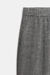 Pantalón gris melange de tiro alto y pierna ancha, con cintura elástica y bolsillos delanteros.