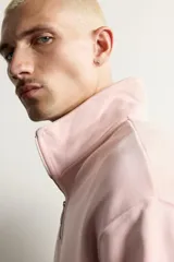 Sudadera de corte regular fit en color rosado, con cuello subido y cierre frontal de cremallera. Presenta manga larga y acabados en rib en puños y ruedo.
