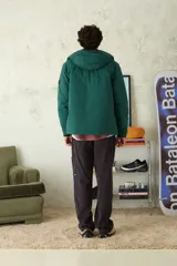 Campera técnica de color azul marino, con capucha integrada, cierre frontal termosellado y puños ajustables con velcro.