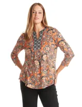 Blusa de seda fría estampada con motivo floral paisley en tonos naranja, negro y beige. Cuello a la base con escote en V y patrón geométrico. Corte holgado con fruncido bajo el pecho y mangas tres cuartos. Ruedo con aberturas laterales y terminación redondeada.