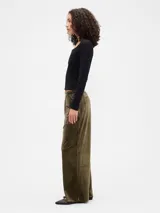 Pantalón de tiro medio y corte recto, confeccionado en terciopelo negro con cintura elástica y bolsillos laterales.