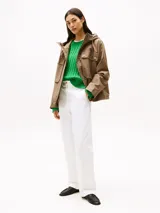 Campera marrón de Tommy Hilfiger con capucha con cordón ajustable, cierre de cremallera oculto con botones a presión, dos bolsillos delanteros tipo sobre con botón, logo metálico en el puño y corte amplio.