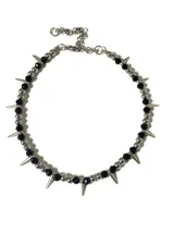 Gargantilla de estilo punk con diseño alternado de perlas de hematite, cristales checos negros y púas metálicas. Incluye cadena regulable de acero.