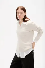 Sweater de tejido de punto color negro, con cuello en V y diseño holgado de manga larga.