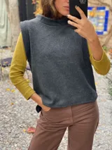 Chaleco de paño de lana gris con cuello alto y diseño sin mangas, de corte recto y holgado.