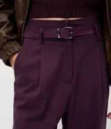 Pantalón de sastrería corte recto, color negro, con pliegues delanteros, cierre de botón y cremallera, y cinturón integrado con hebilla metálica.