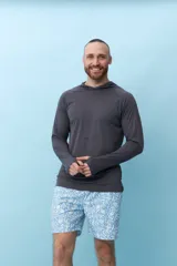 Remera gris de manga larga con capucha y orificios para los pulgares.