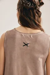 Maxi vestido negro sin mangas, con cuello redondo y silueta suelta que se abre en A hacia el ruedo. Confeccionado en 100% algodón, incluye aplique trasero en forma de X.