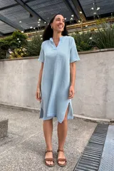 Vestido tejido color celeste, con escote en V, mangas cortas y aberturas laterales.