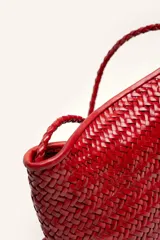 Cartera tipo morral y bandolera de cuero vacuno marrón, completamente trenzada a mano con diseño estructurado y correa larga trenzada.
