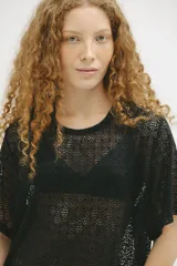 Remerón negro de tejido calado con mangas cortas y corte oversize.