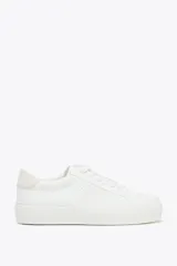 Championes de estilo urbano en color blanco, con diseño de cordones y suela de plataforma de 3,5 cm. Presentan detalles de pespuntes decorativos y una textura sutil en los laterales.